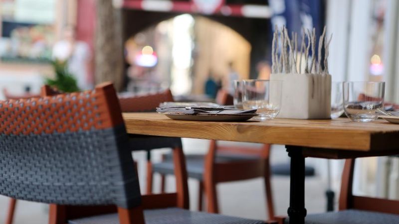 Gedeckte Tische in einem Restaurant mit Blick durchs Fenster