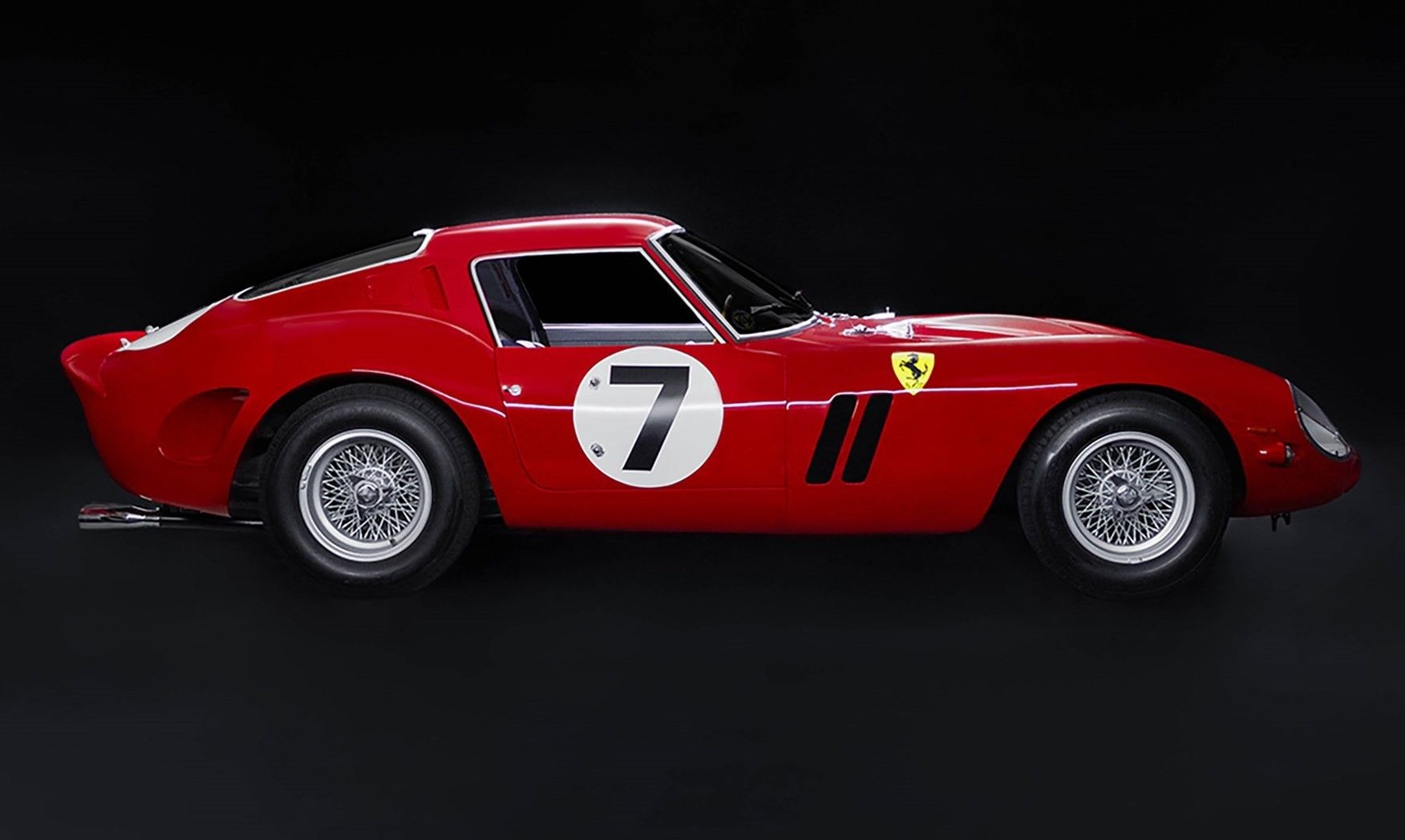 Ferrari 330 LM / 250 GTO 1962, side view, rosso corsa with number 7, wire wheels, prancing horse badge, dark background. RM Sotheby's auction photography.