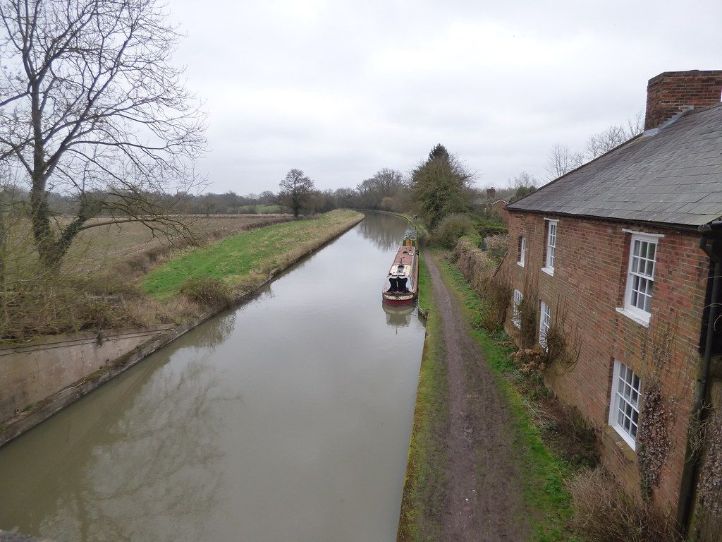 Grand Union Canal at Hatton with a towpath, a moored narrowboat and brick cottages beside the water