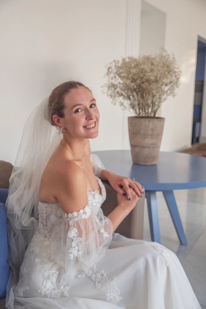 Portrait of a smiling bride in a lace corset gown and veil indoors in Cyprus