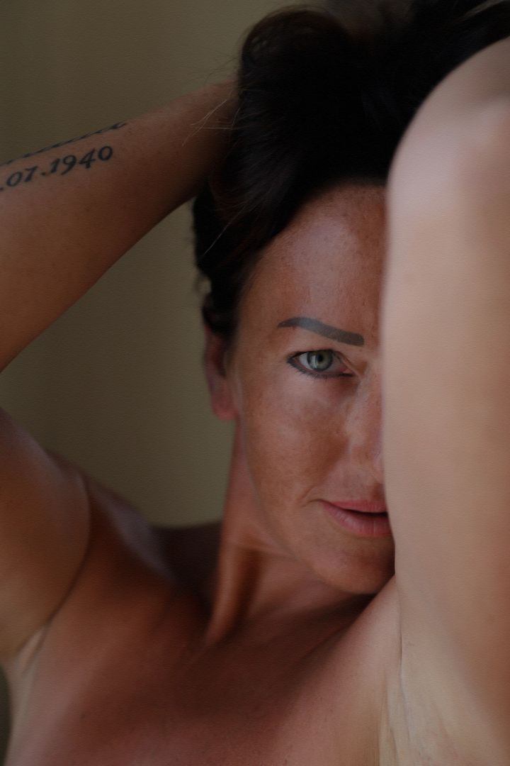 Close-up beauty portrait of a woman with freckles and striking green eyes in soft natural light, Cyprus