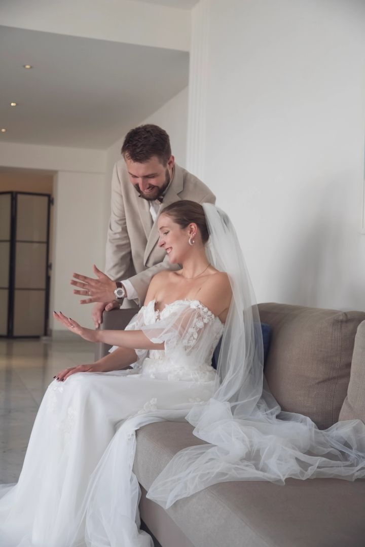 Bride and groom sharing a getting-ready moment on a sofa before their Cyprus wedding