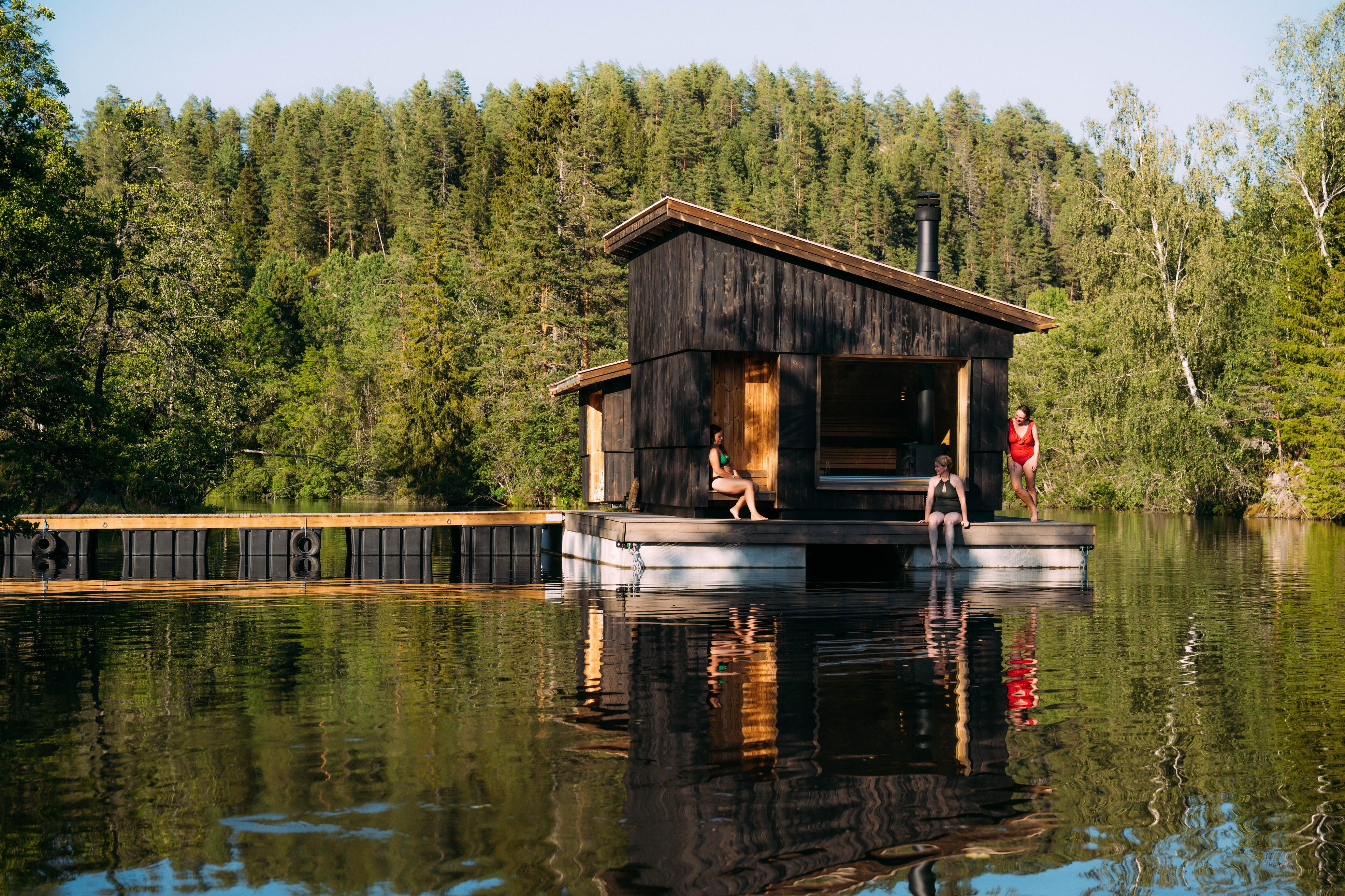 Three women sitting outside on a floating sauna