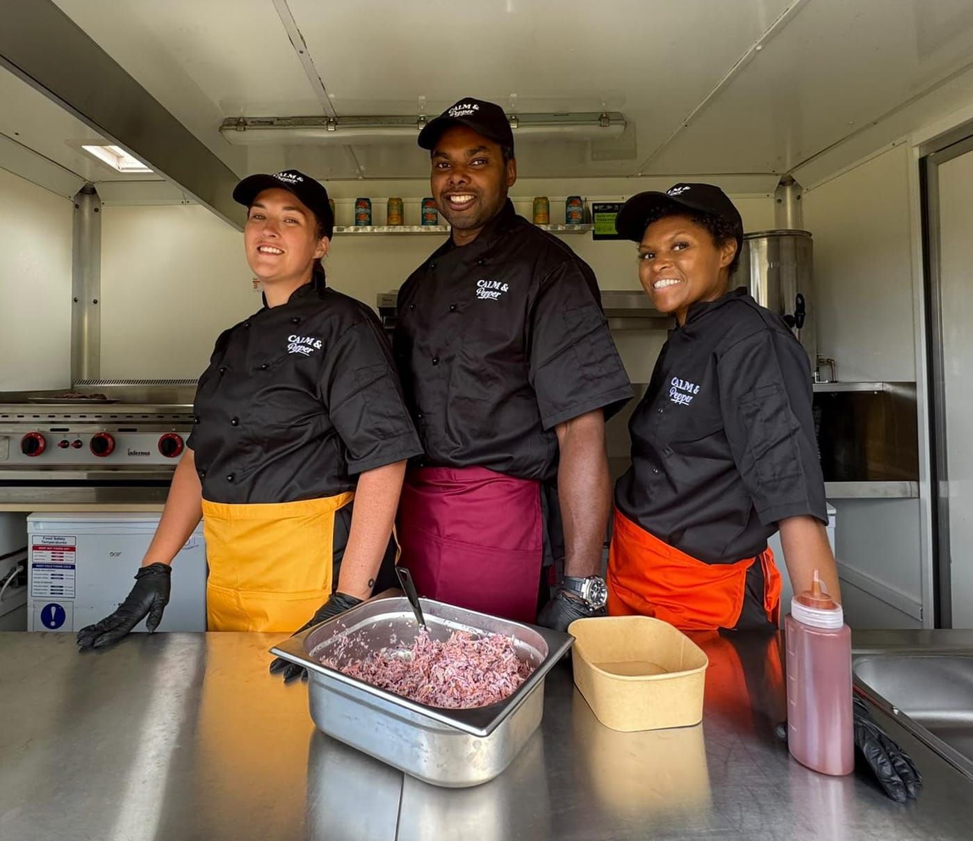 Three of the team inside the trailer kitchen