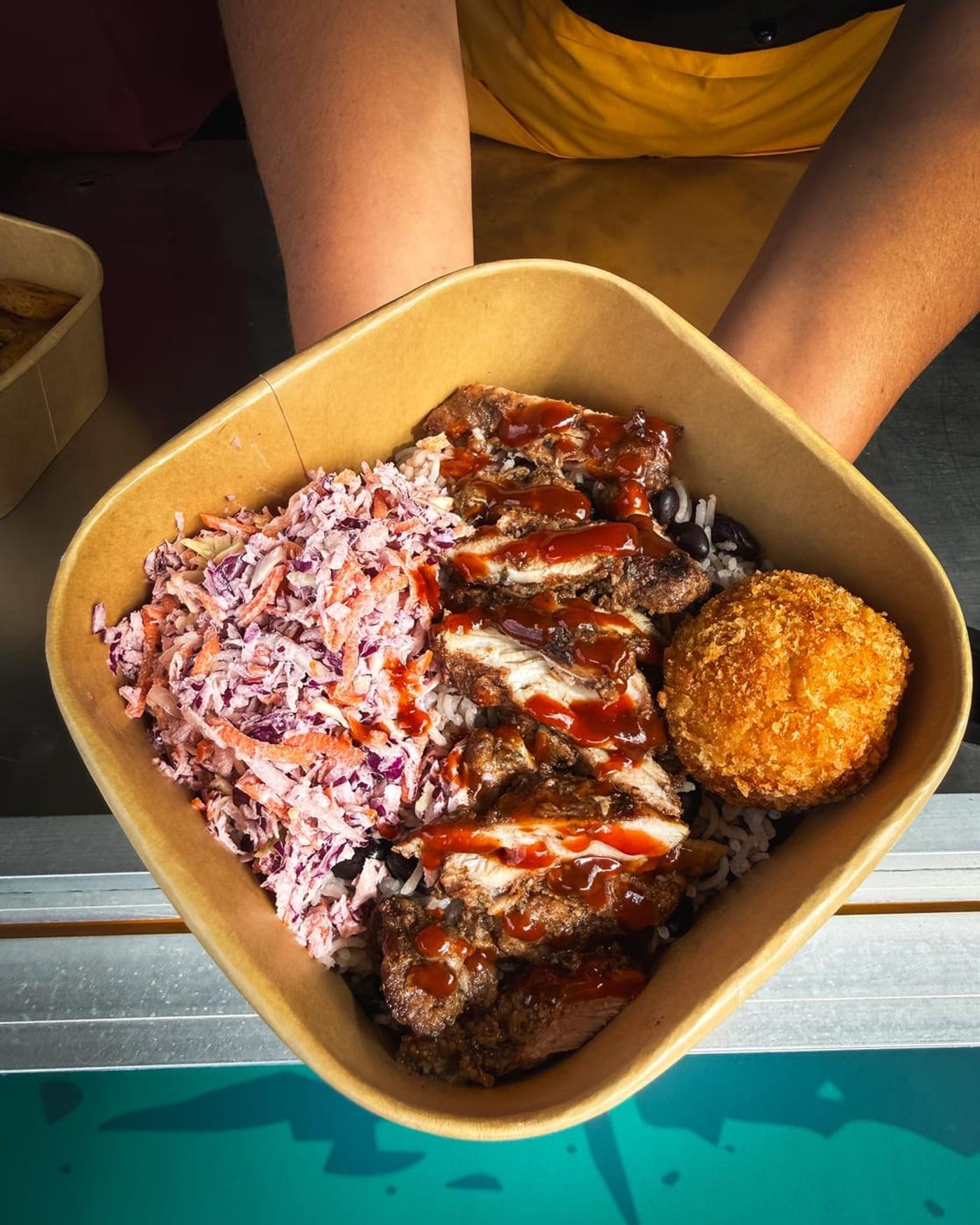 Jerk chicken bowl held up to the camera