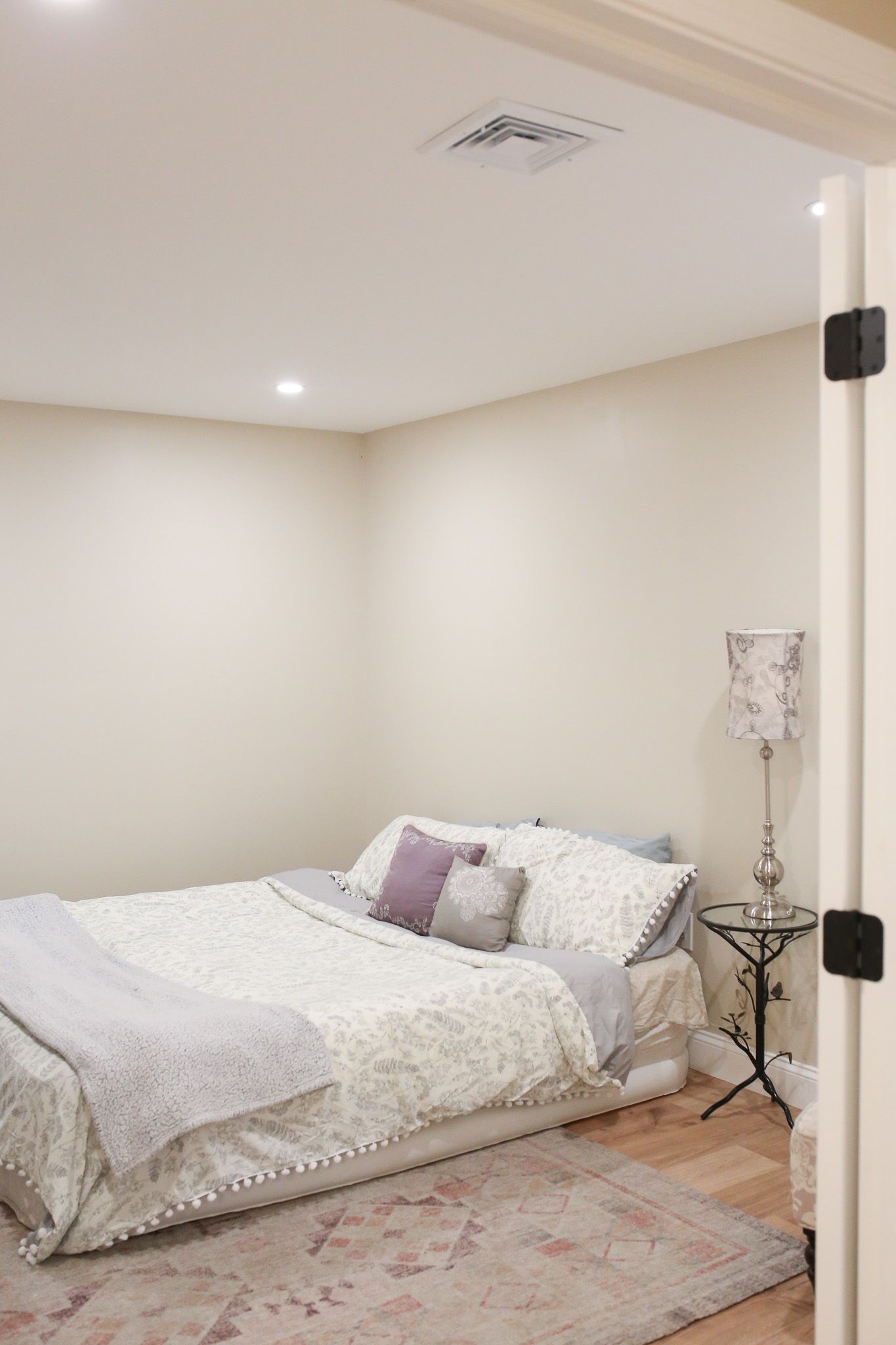 bed with white sheets and neatly organized through pillows