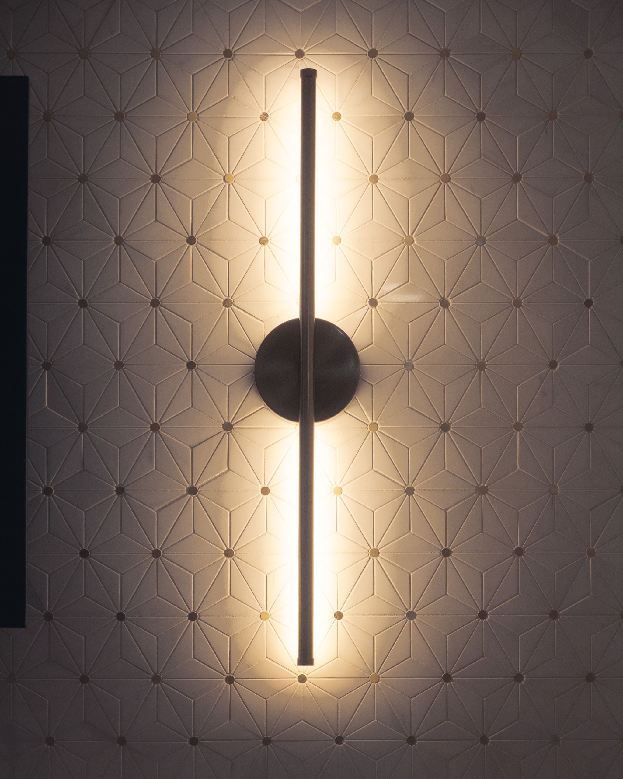Sconce light on tile backsplash