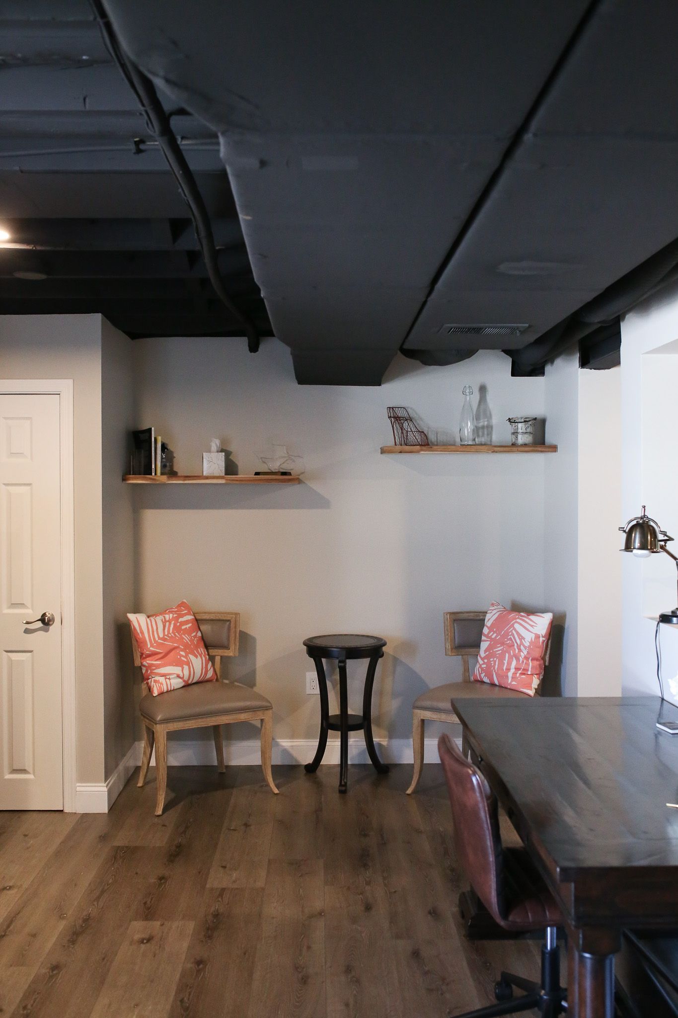 chairs and a table in a basement with a black ceiling