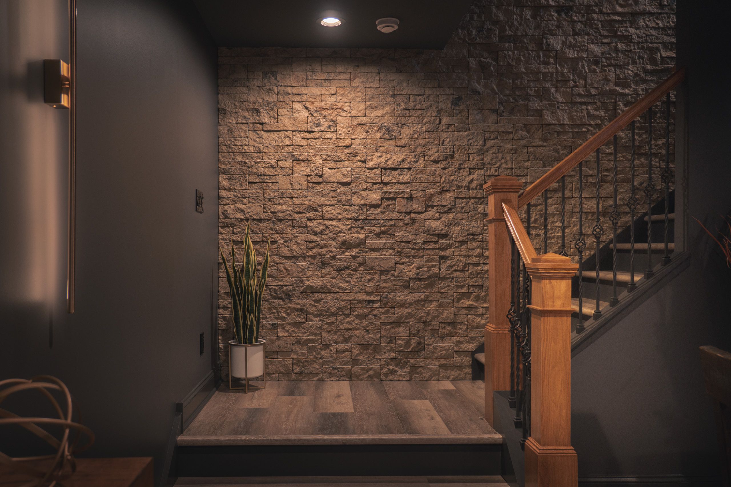 Stairway with gray faux stone on the walls
