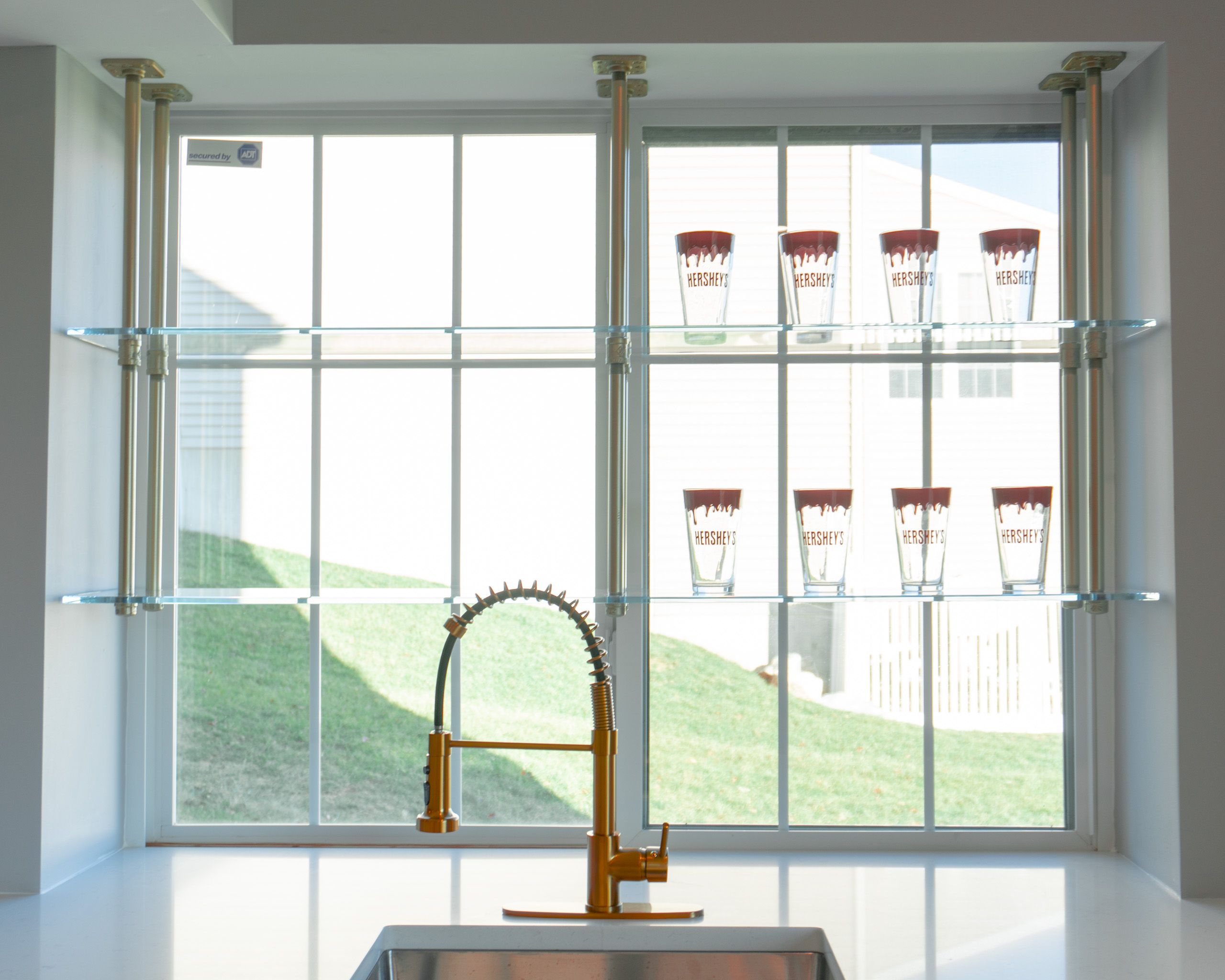 Wet bar with glass shelves behind the faucet