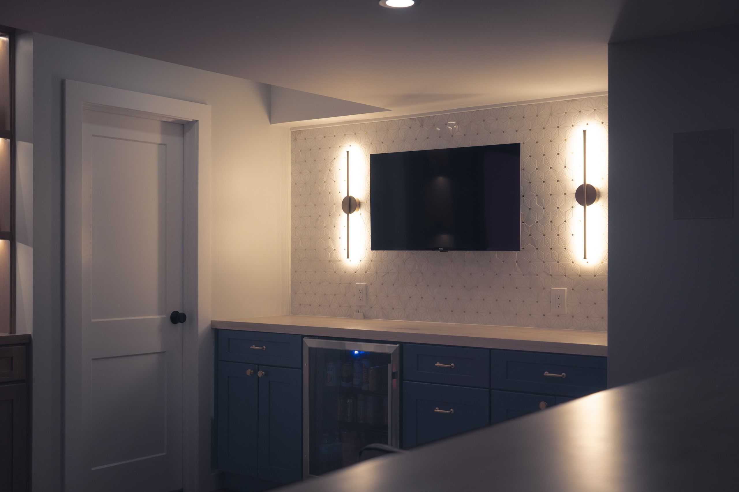 Dry bar with tile backsplash and sconce lights