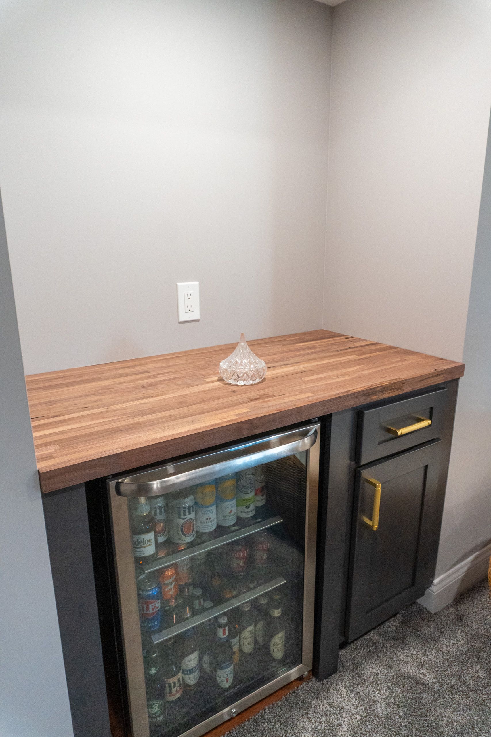 Top view of a dry bar with butcher block countertop and grey cabinets