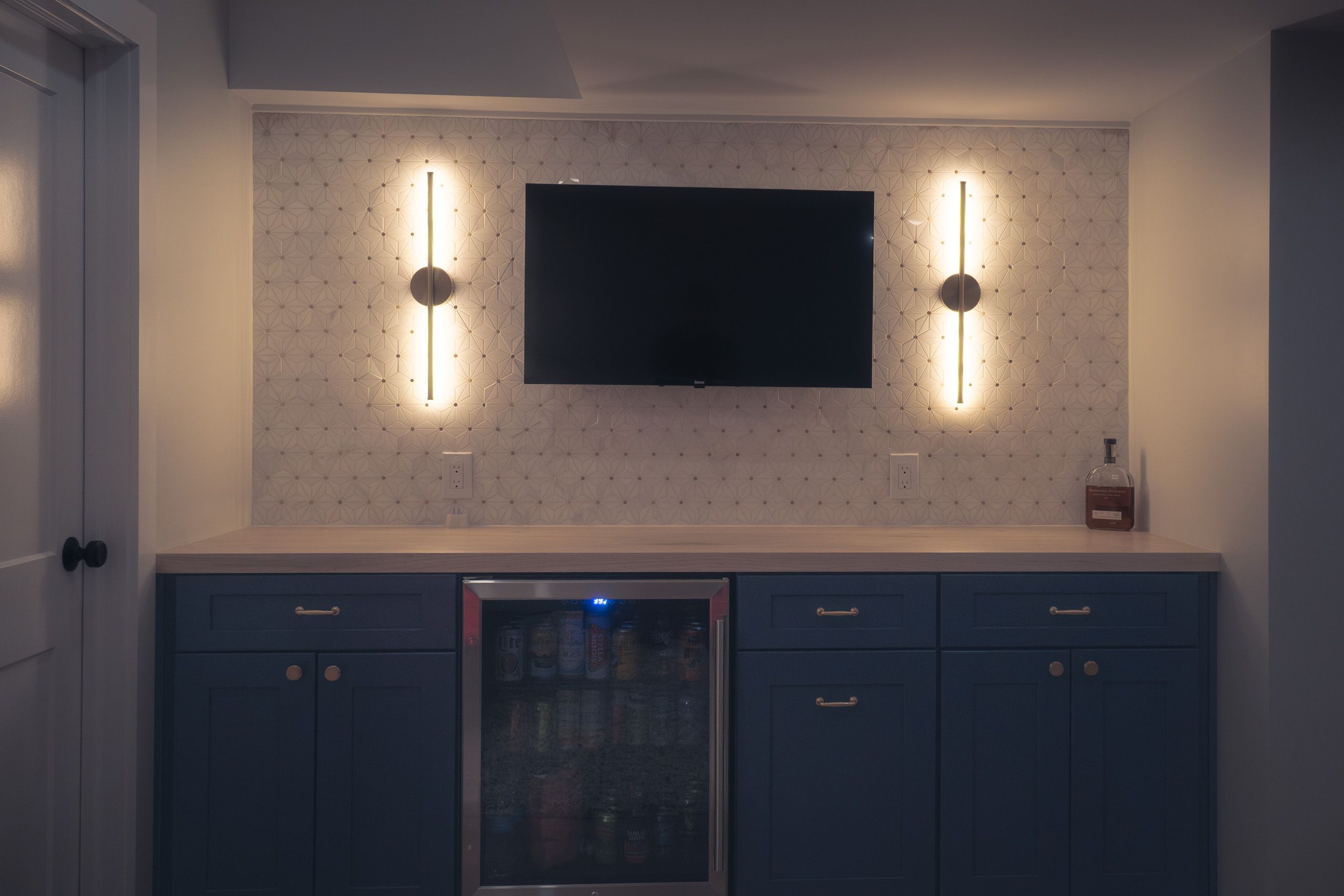 Dry bar with tile backsplash and sconce lights