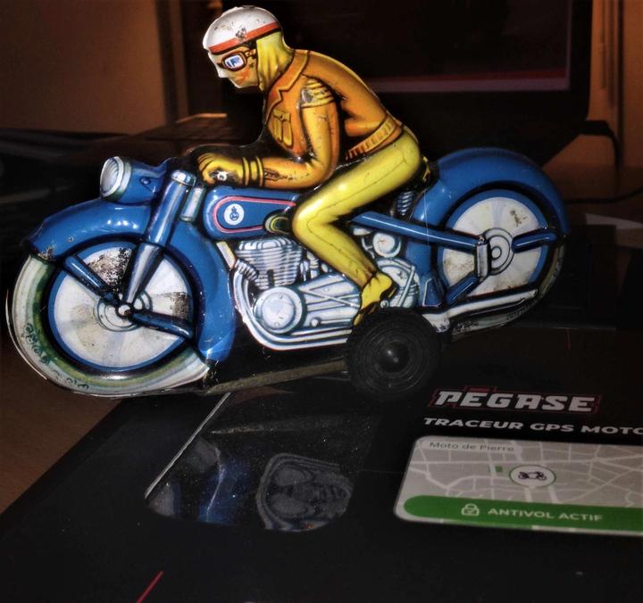 Un motard sur sa moto jouet à friction en fer blanc pour collectionneur