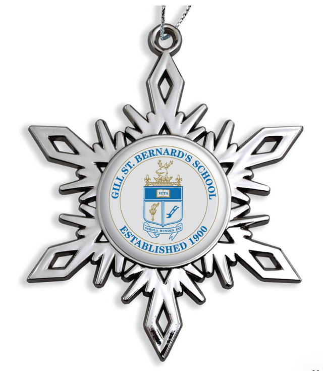 Silver metal snowflake ornament with a round white center insert printed with a private school's blue and gold crest and founding year, on a silver cord
