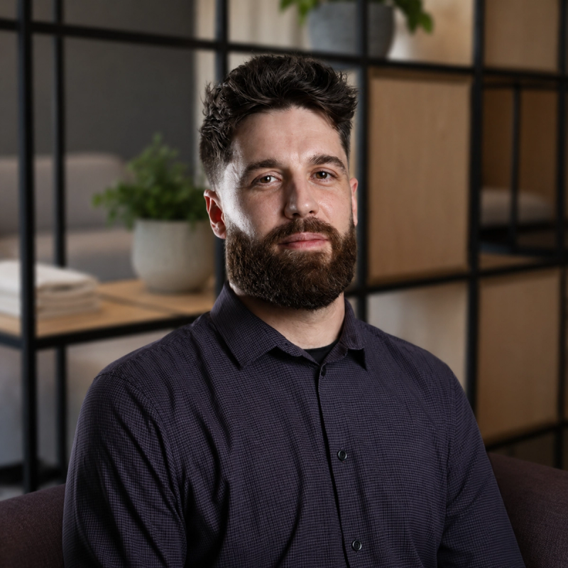 An approachable team member in a shirt sitting in a modern office setting