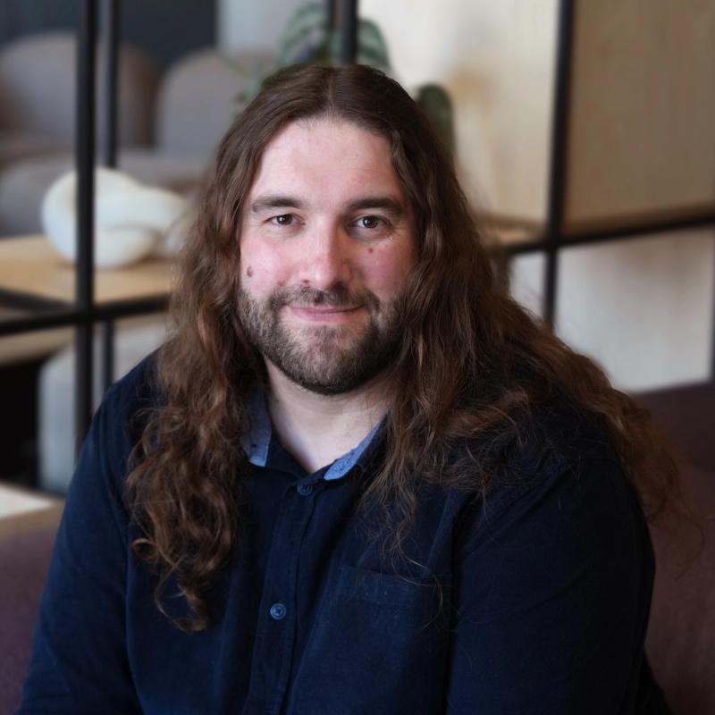 A smiling, friendly team-member in a modern office environment