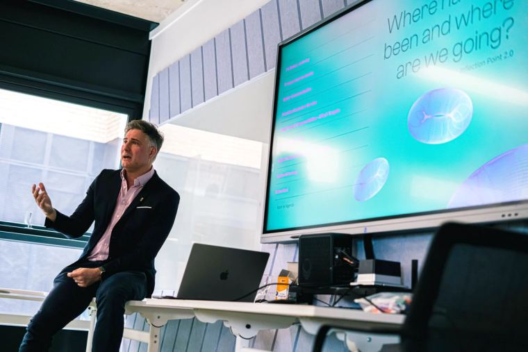 Inflection Point's managing director presenting a plan on screen to a seated audience