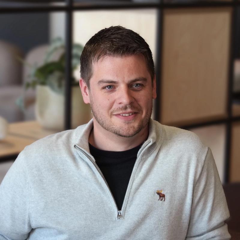 A smiling, approachable team-member in business-casual attire