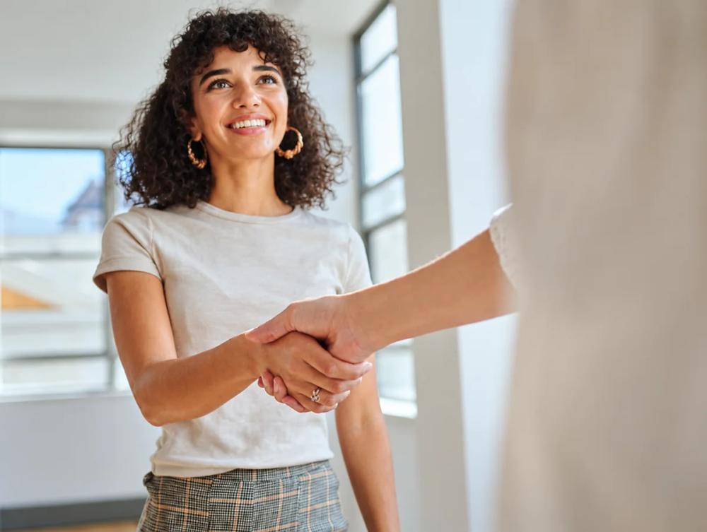 Two professionals shaking hands in a bright modern office