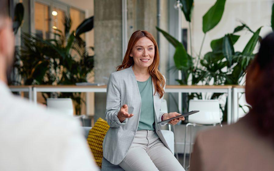 A woman with a tablet leading a relaxed group discussion