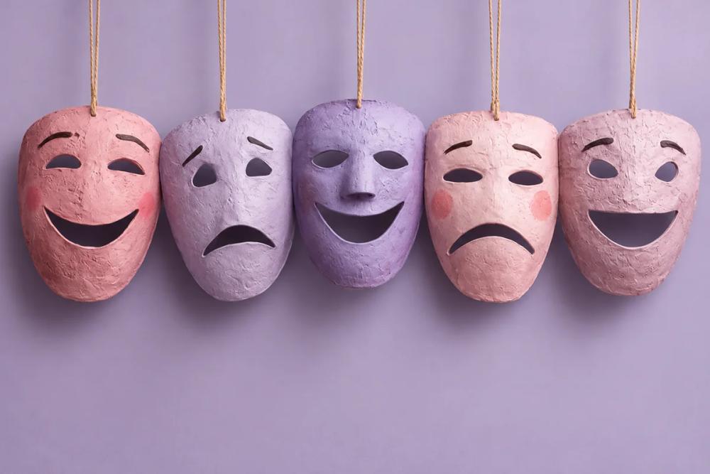Five theatrical masks with alternating happy and sad expressions