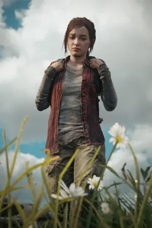 A low angle shot of Ellie, frowning in thought, looking down at some daisies growing in the grass.