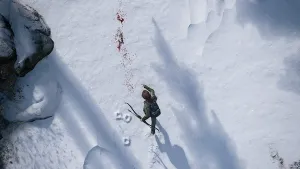 An overhead shot looking directly down at Ellie, running through snow, following a trail of blood and tracks.