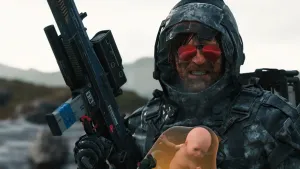 A close up of Sam grimacing toward the camera after a BT battle. His suit hood is up and he’s wearing red-lensed mirrored sunglasses. His face and suit are covered with black stains and he’s holding up a non-lethal assault rifle.