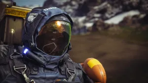 A close of up Sam in a mountain valley, wearing a full-face oxygen mask. His suit’s hood is up and the sunlight reflects off the mirrored face screen.