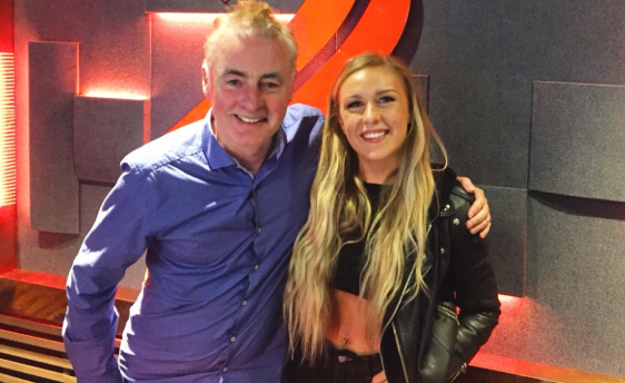 Ciara O'Connor performing stand-up comedy on stage while sharing funny dating stories with the audience