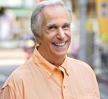 Henry Winkler posing in his iconic black leather jacket from the classic television sitcom Happy Days.