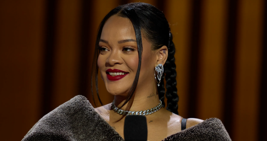 Rihanna smiling during a public event and showing her signature style