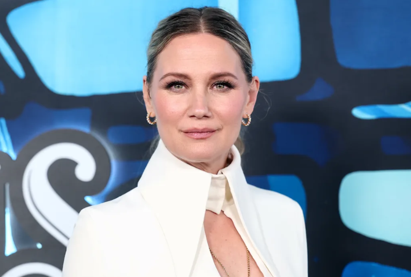 Alt Text: Country music star Jennifer Nettles singing live on stage into a microphone during a concert performance.