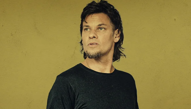 Theo Von performing his unique style of stand-up comedy on a bright stage.
