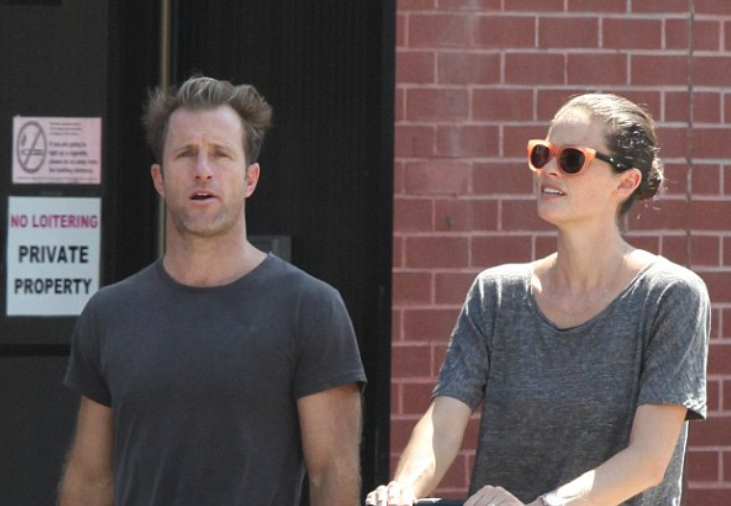 Kacy Byxbee and her longtime partner actor Scott Caan smiling together as they arrive at a Hollywood red carpet event.