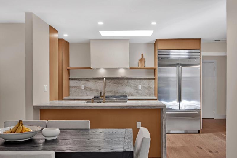 Castle Hill Ranch kitchen from dining area, white oak cabinetry with marble countertops and Sub-Zero refrigerator