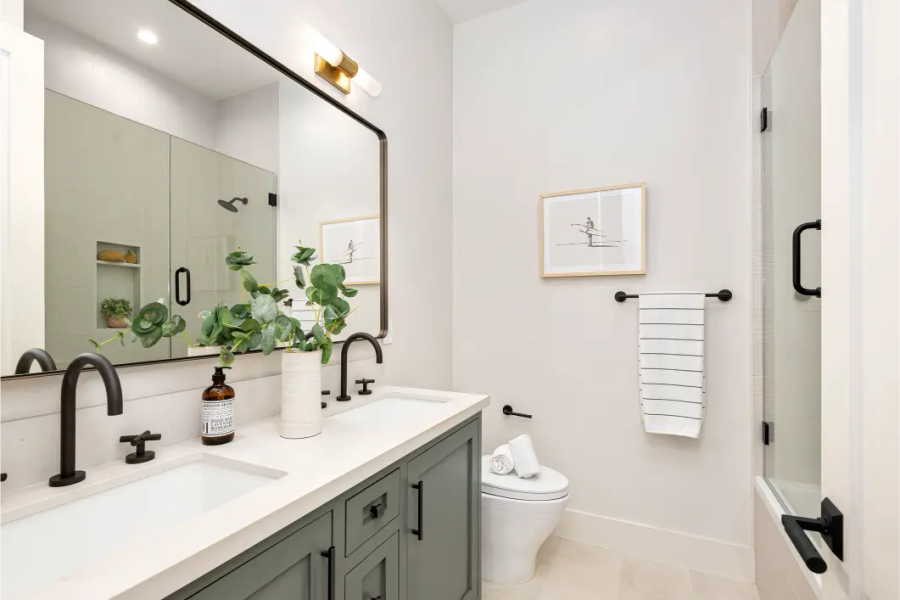 Updated bathroom in older Redwood City home — sage green vanity, black fixtures, tub-shower combination