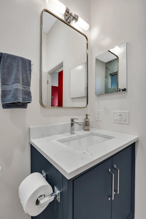 Guest bath, vanity detail with rounded mirror and chrome fixtures
