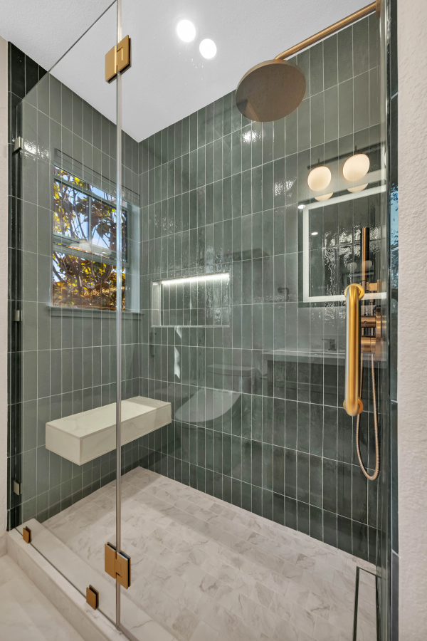 Guest bathroom, deep green vertical tile shower with brass rain head, LED niche, and floating marble bench