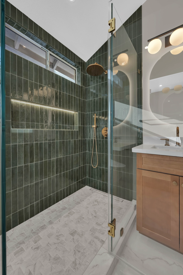 Master bath, shower interior with brass rain head, hand shower, and LED-lit niche