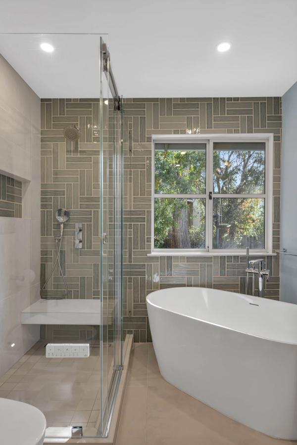 Master bath, freestanding soaking tub with garden window and tile feature wall