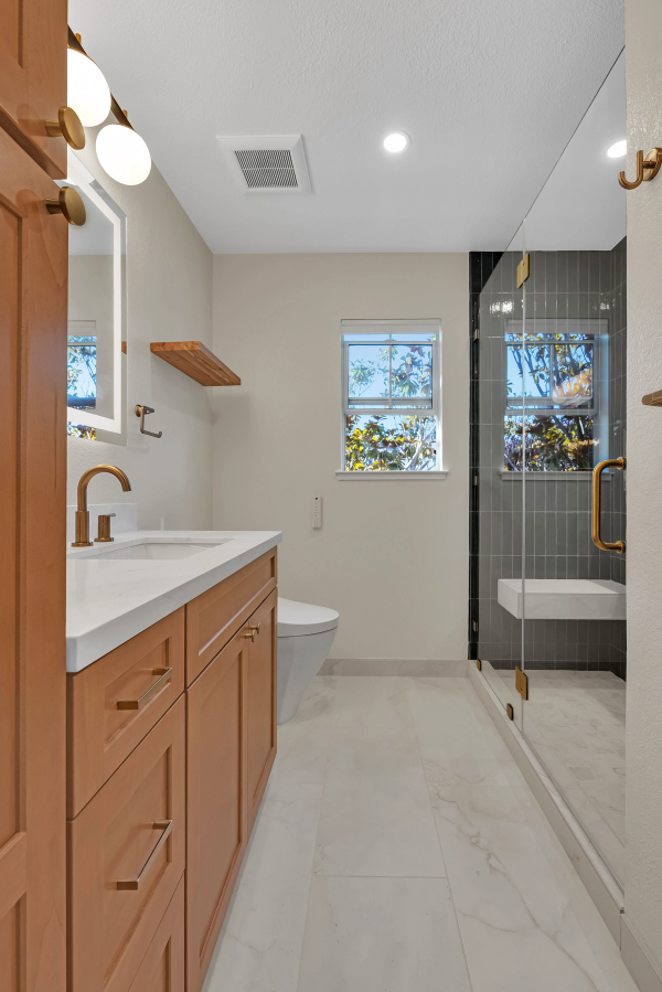 Guest bath, full room with maple vanity, glass shower, and green tile