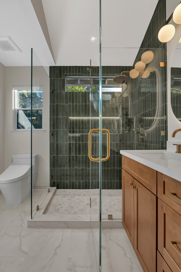 Master bath, walk-in shower with deep green vertical tile and frameless glass door