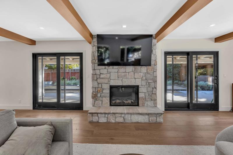 Kitchen island with brushed gold faucet looking through to living room fireplace