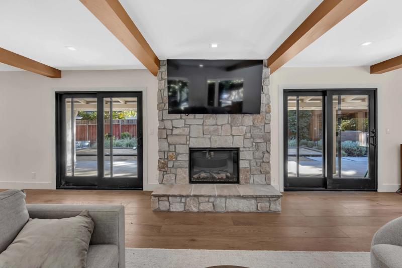Kitchen island with brushed gold faucet looking through to living room fireplace