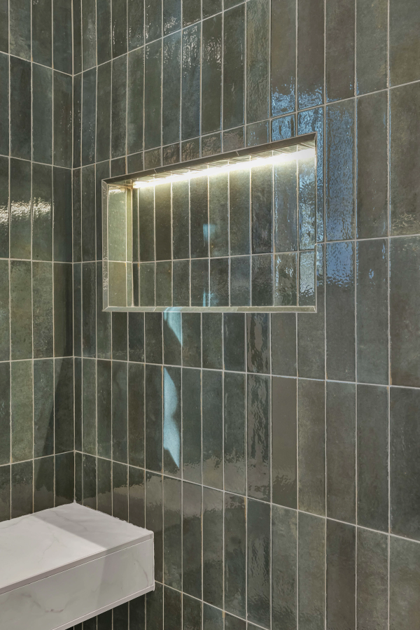 LED-lit recessed shower niche in green glazed tile