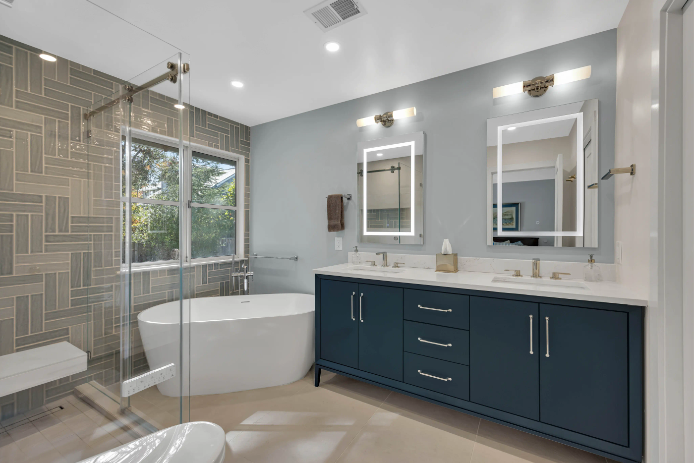 Custom luxury bathroom remodel in Redwood City — navy vanity, herringbone tile shower, freestanding tub by Bark and Build Builders