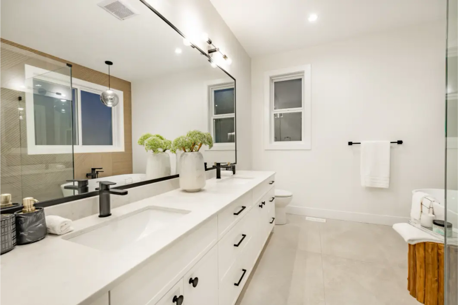 Floating light oak double vanity with black-framed mirrors and white quartz — bathroom layout planned around existing drain stack