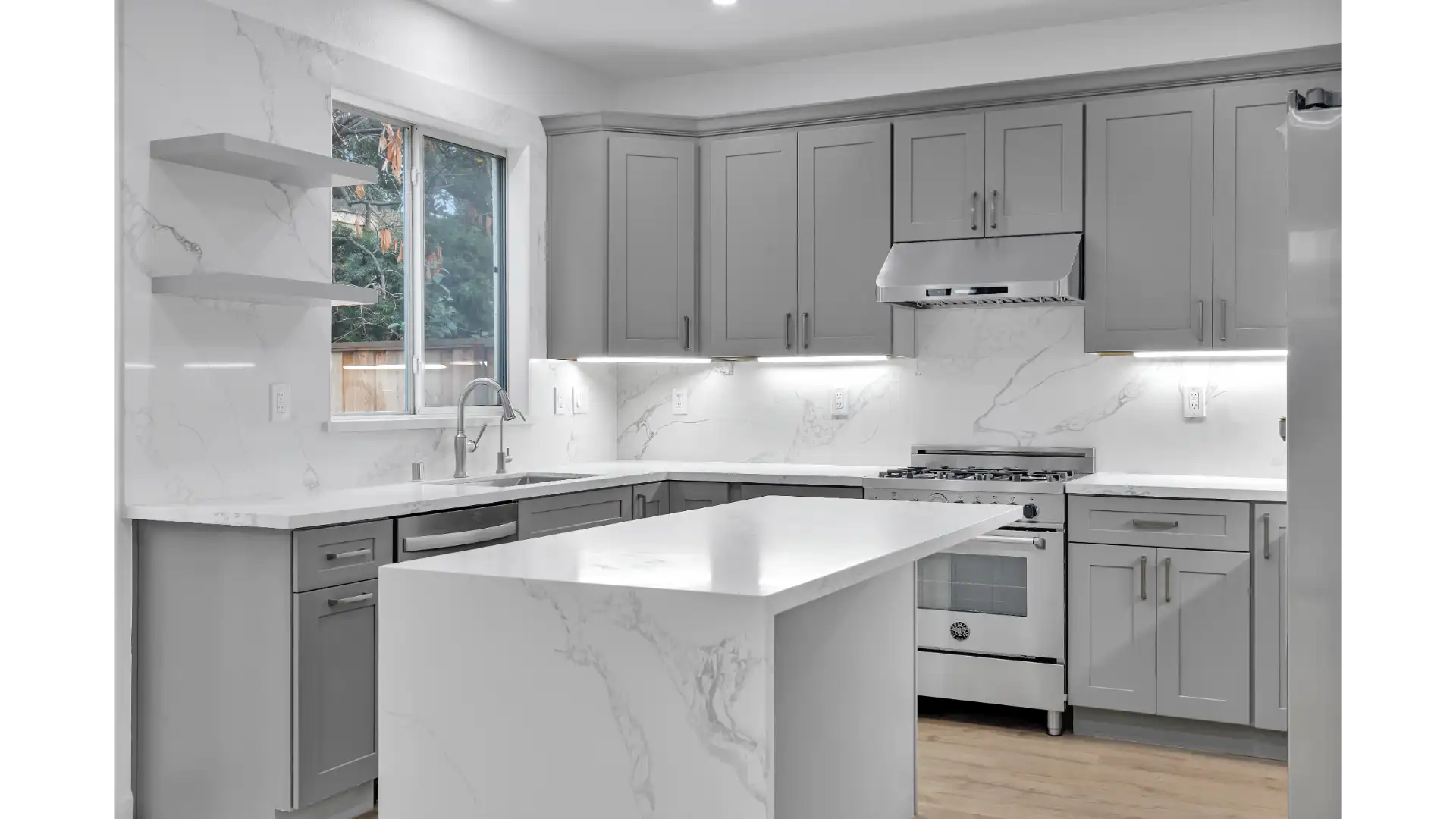 Open concept kitchen layout — quartzite island and integrated appliances